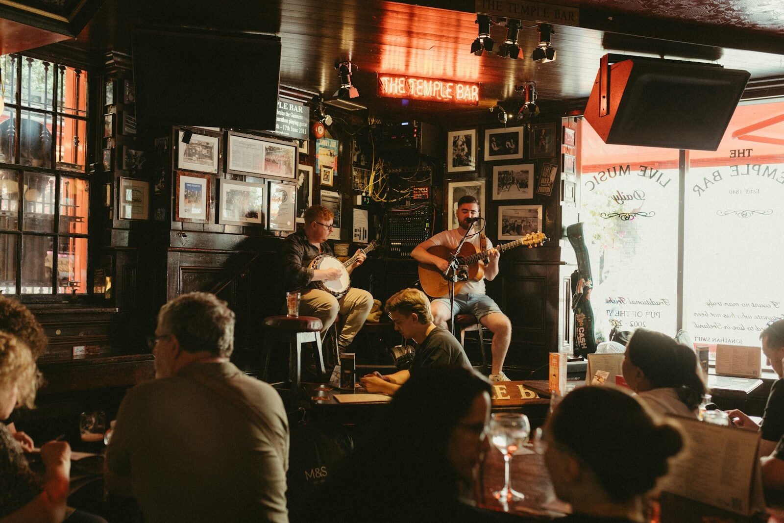 Two musicians perform live music in a cozy pub